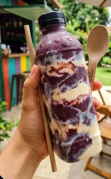 Garrafa ilustrativa de açaí com morangos, frutas e complementos